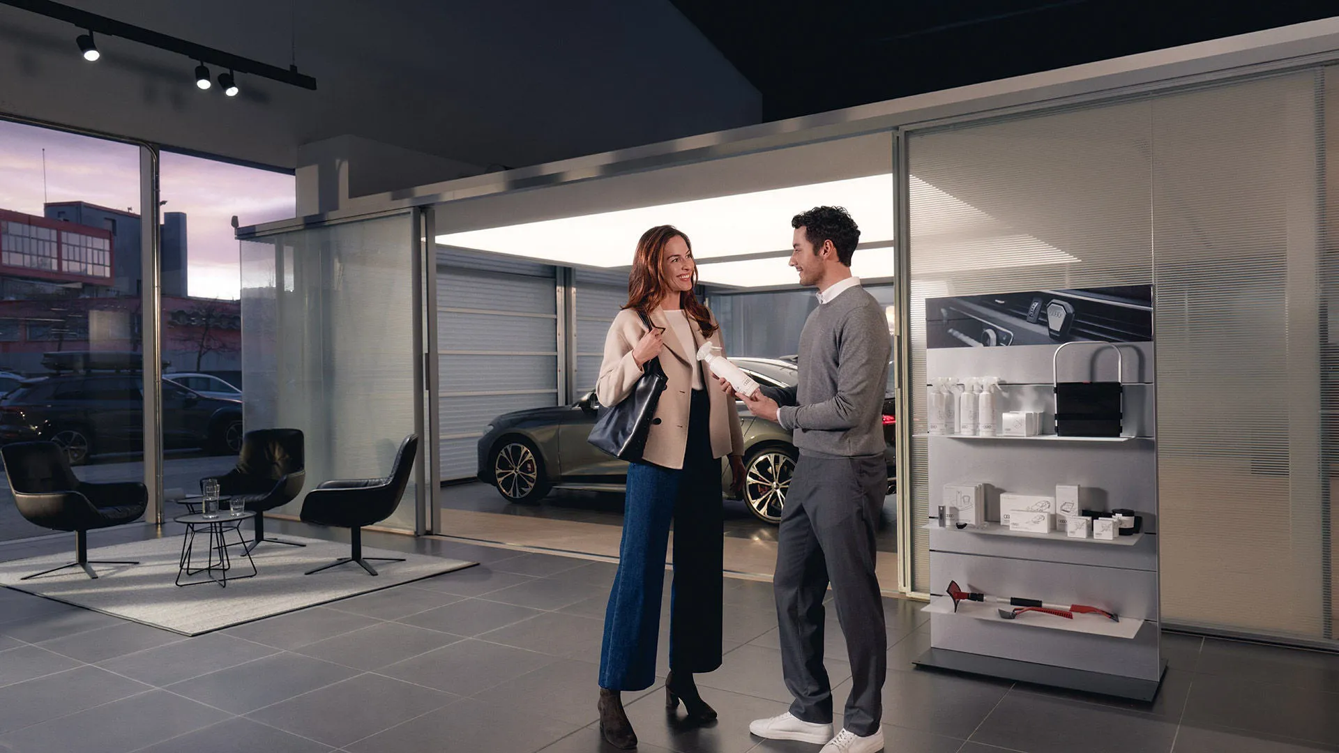 An Audi employee speaking with a client in a dealership.