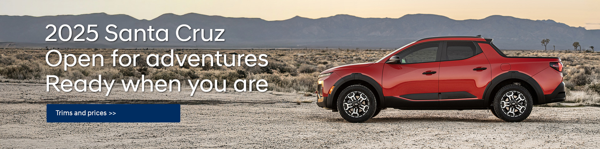 A red 2025 Santa Cruz  parked in a desert, with a mountain range in the background