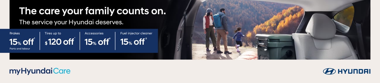 A family preparing for a fall hike seen through the open liftgate of a Hyundai SUV. Text: The care your family counts on. The service your Hyundai deserves.