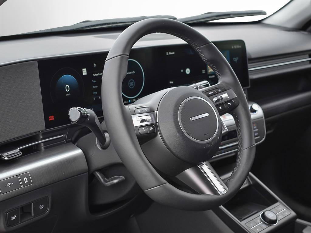 Kona EV Ultimate 2026 Intérieur, vue du poste de conduite à travers la porte du conducteur ouverte. L'intérieur est spacieux et orienté vers le conducteur.