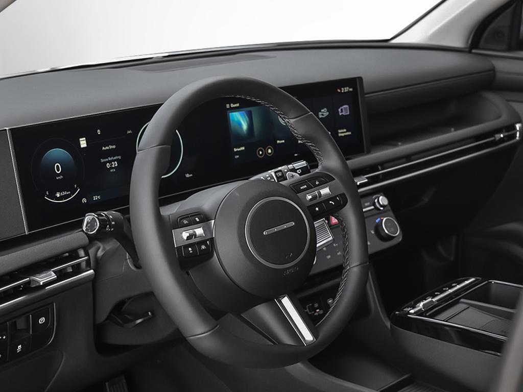 Vue du poste de conduite et de l'habitacle du Tucson 2026 par la portière du conducteur ouverte.