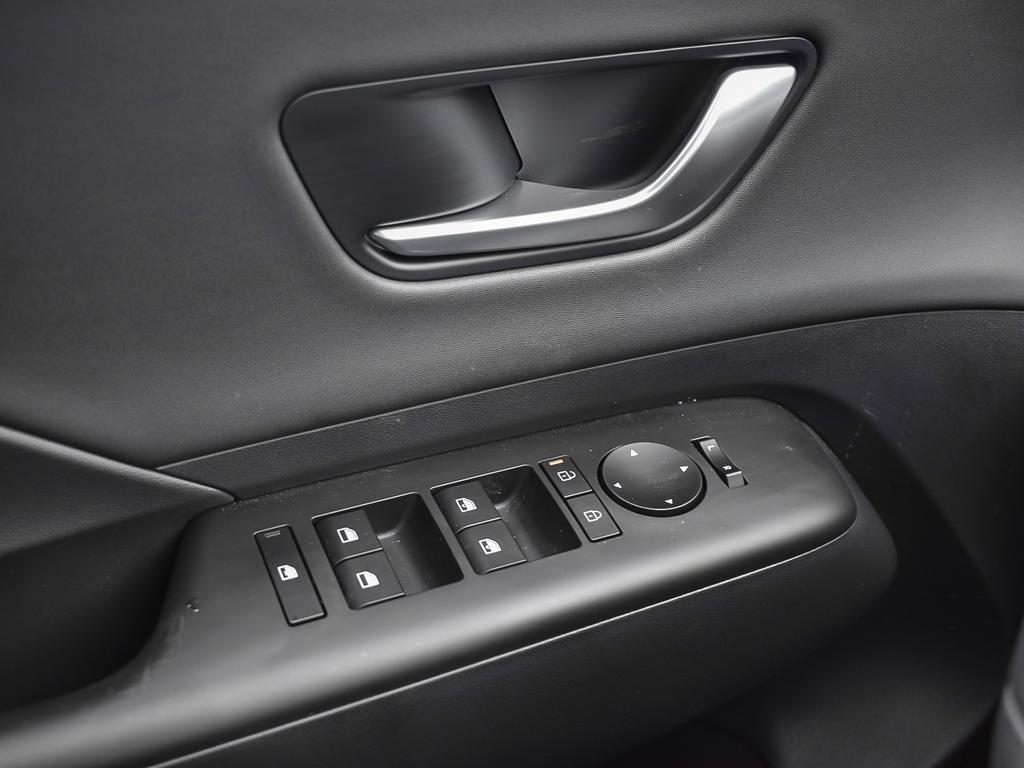Kona EV Ultimate 2026 Intérieur, commandes des vitres électriques sur la portière du conducteur. Matériaux doux au toucher sur le panneau.