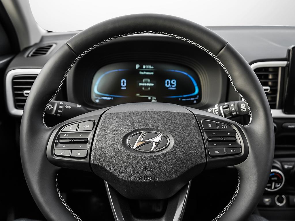 Gros plan sur le volant gainé de cuir et ses commandes intégrées