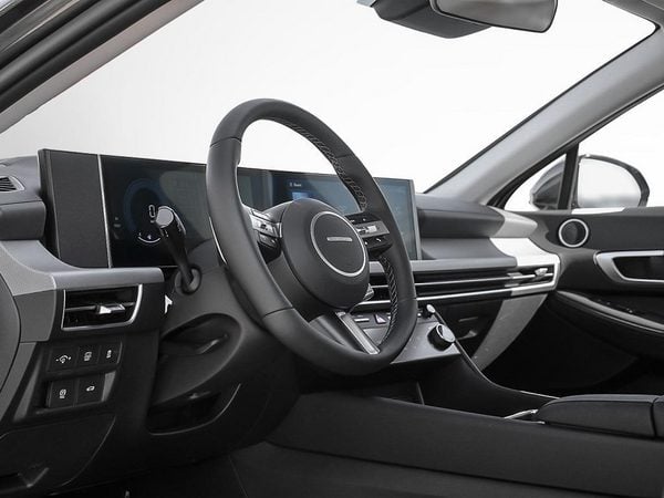 Driver's cockpit of the 2026 Hyundai Sonata Hybrid through the open door.