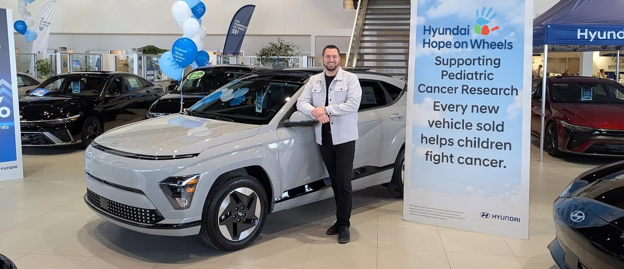Daniel, Brossard Hyundai advisor, in front of the 2026 Hyundai Kona Electric at 8750 Taschereau Blvd.