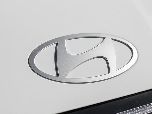 Gros plan du logo Hyundai sur la calandre de la Sonata Hybride 2026 Blanc Serenity nacré